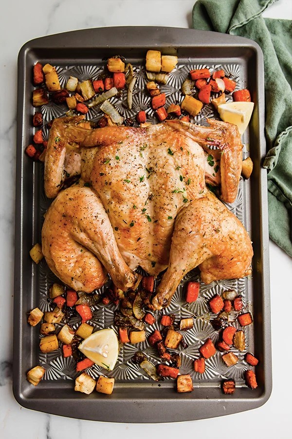 Spatchcocked chicken and vegetables on a sheet pan.