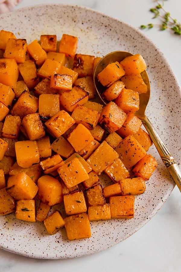 Butternut squash with a spoon on a plate.