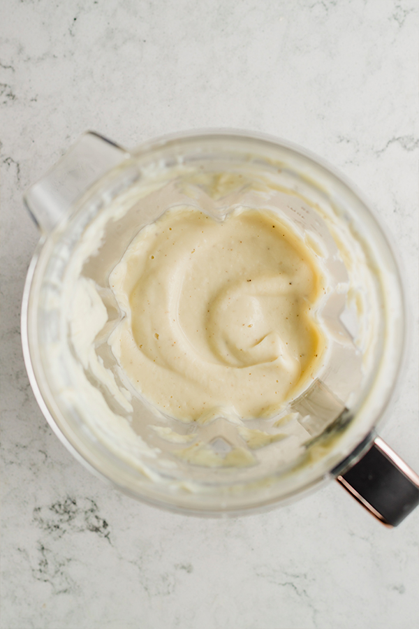 A blender filled with alfredo sauce.