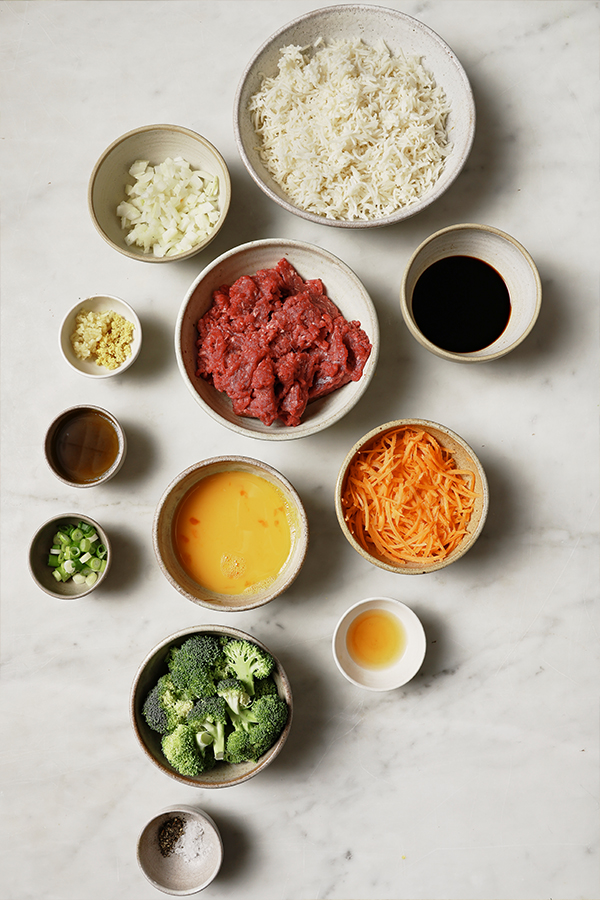 Ingredients including shredded carrots, broccoli, and eggs.