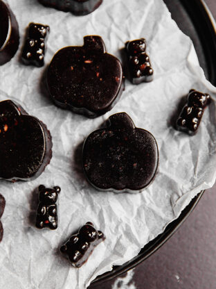 Black Halloween gummies on a lined dish.
