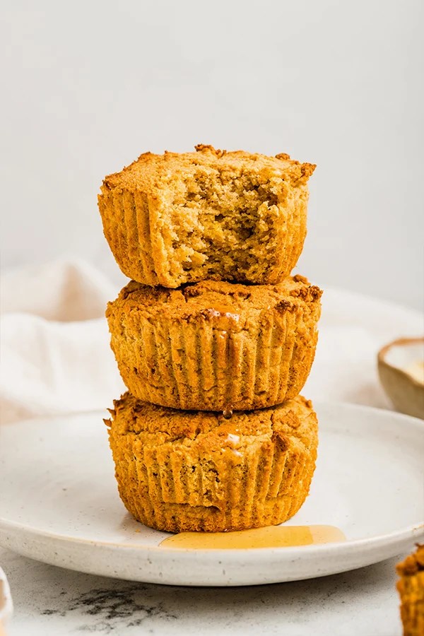 Stack of cornbread muffins, one of which is missing a bite.