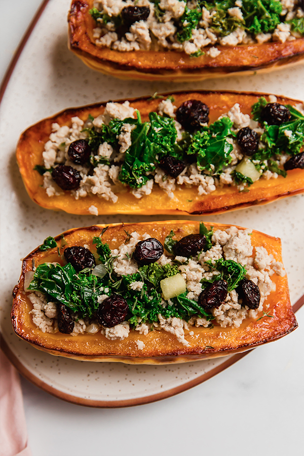 Several stuffed Delicata squash on a plate.
