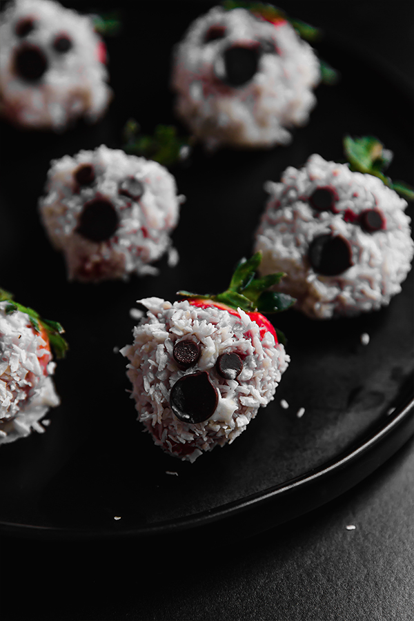Plate of coconut butter covered strawberry ghosts.