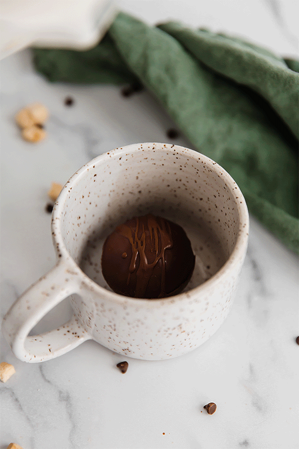 Gif of hot milk pouring over a hot cocoa bomb.