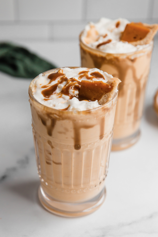 Two pumpkin pie milkshakes in glasses.