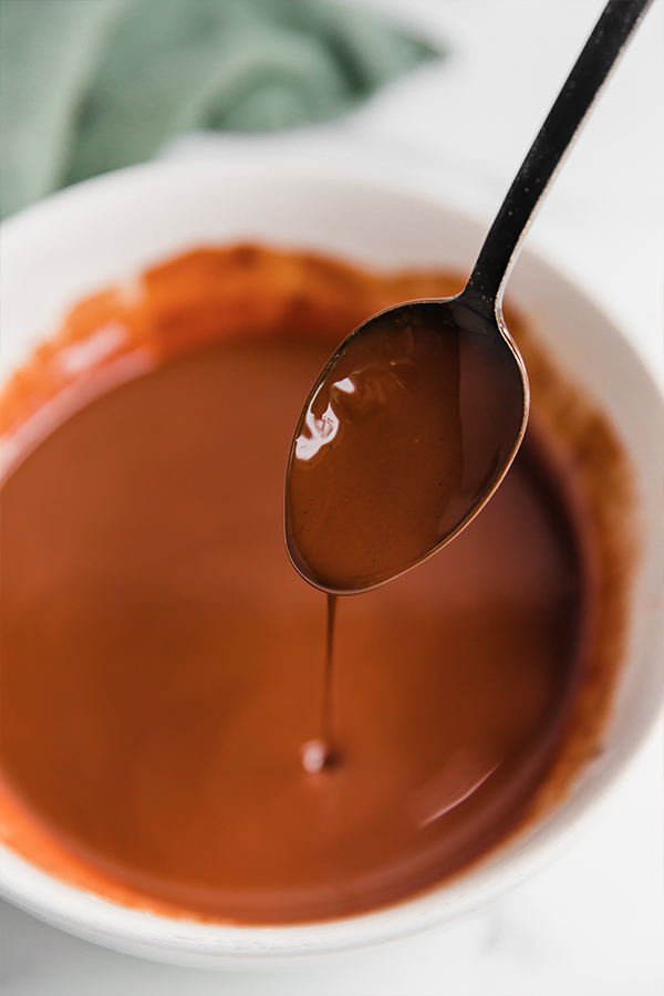 Melted chocolate drizzling from a spoon.