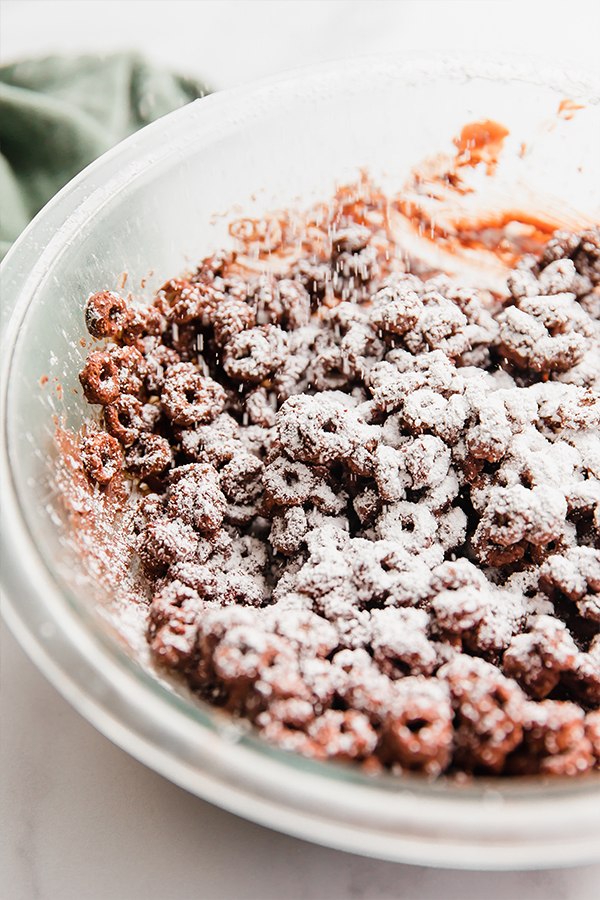 Powdered sugar dusting onto chocolate-covered cereal.