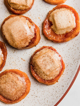 Sweet potato casserole bites topped with marshmallow and cinnamon on a platter.