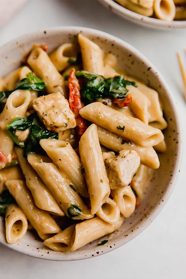 A bowl of creamy Tuscan chicken pasta.