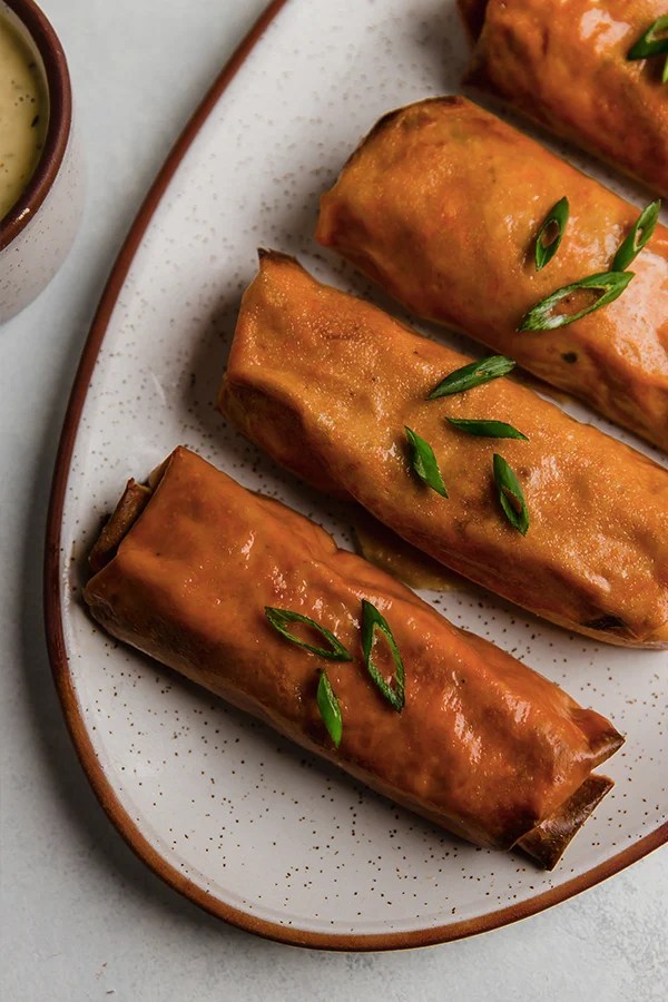 Buffalo chicken egg rolls on a plate.