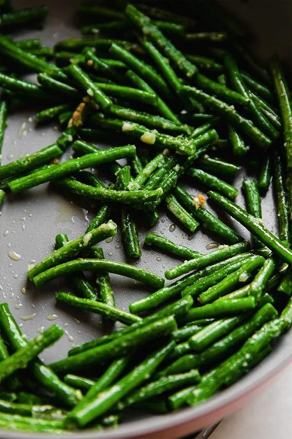 Green beans cooking in a pan.