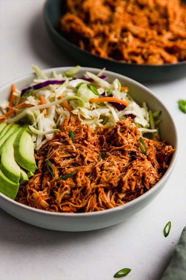 Bowl of vegetables and shredded barbecue chicken.