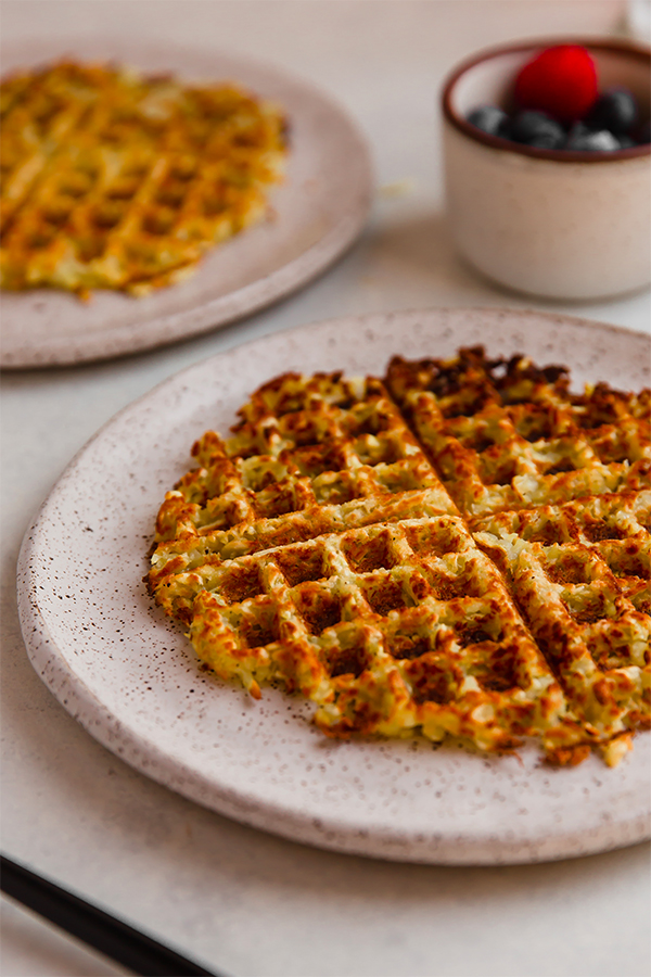 A sweet potato hashbrown waffle on a plate.