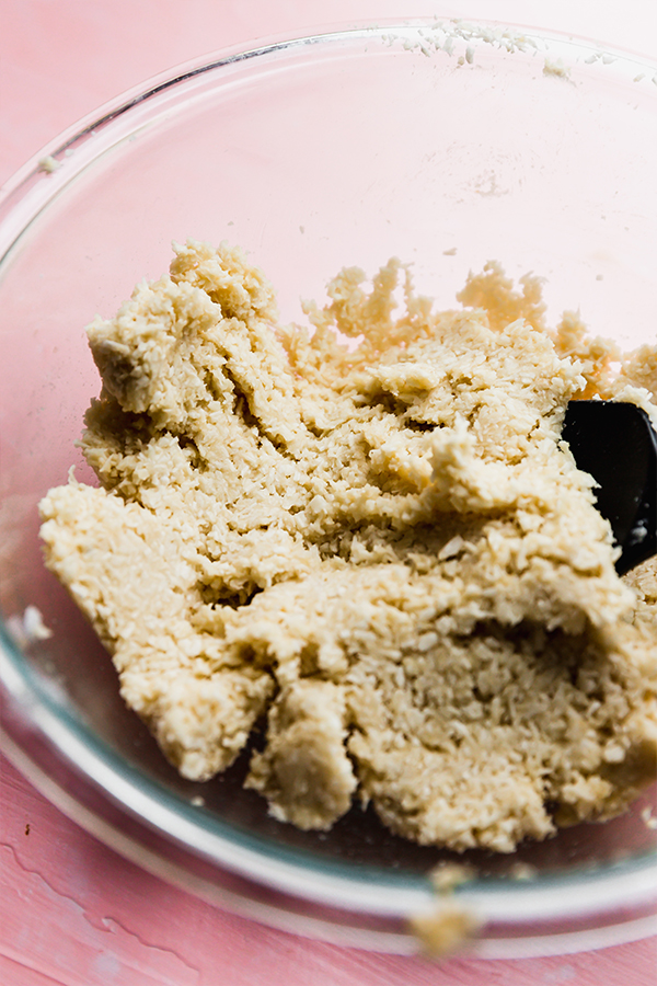 The dough for coconut macaroons in a glass bowl.