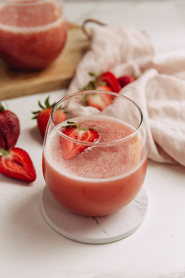 Homemade Frose in a glass with a strawberry slice.