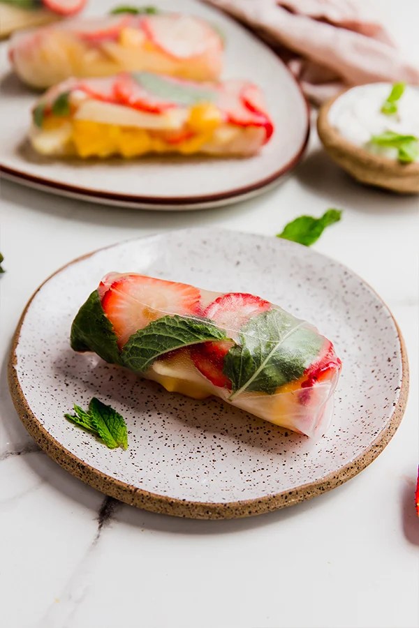 A fruit spring roll on a plate.