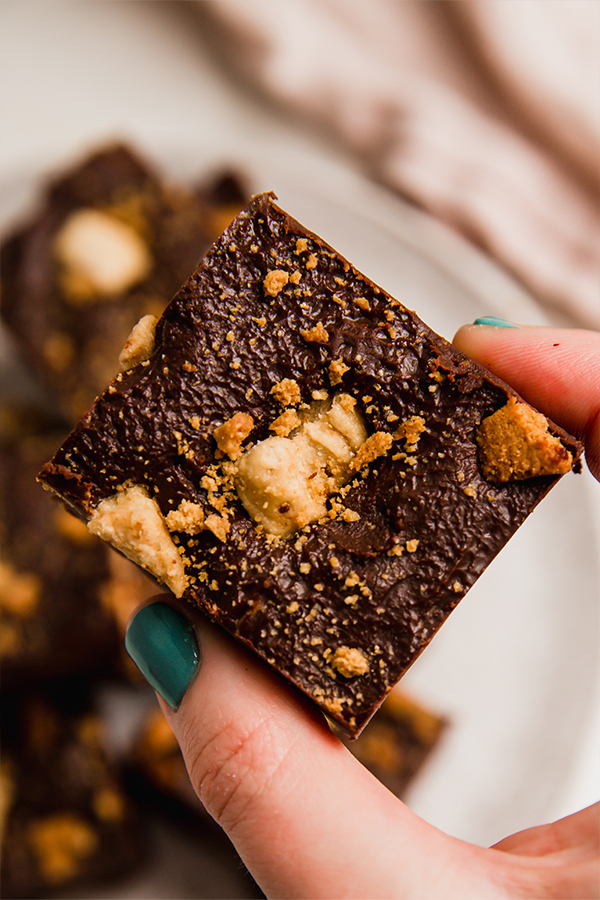 A piece of s'mores fudge being held.