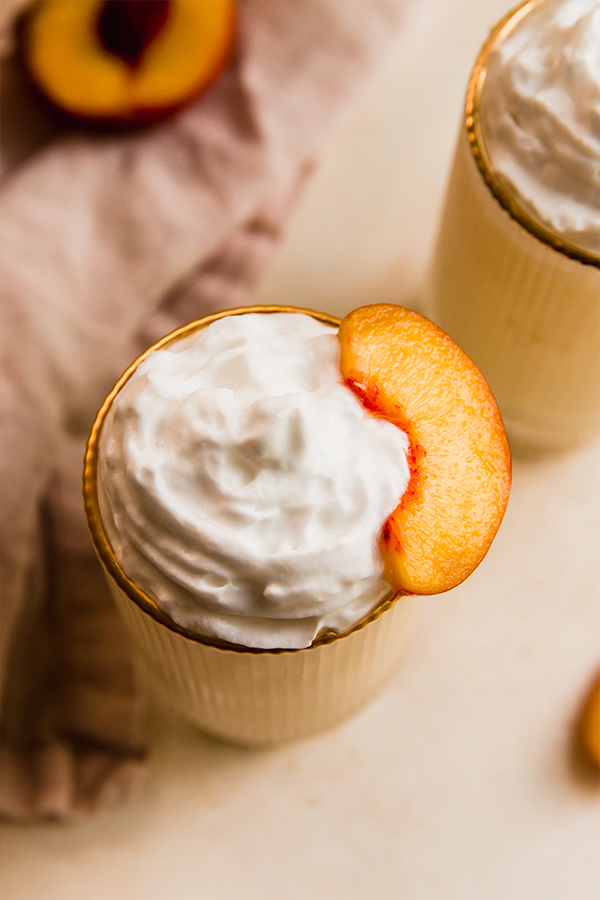 Coconut whipped cream on a peach milkshake.