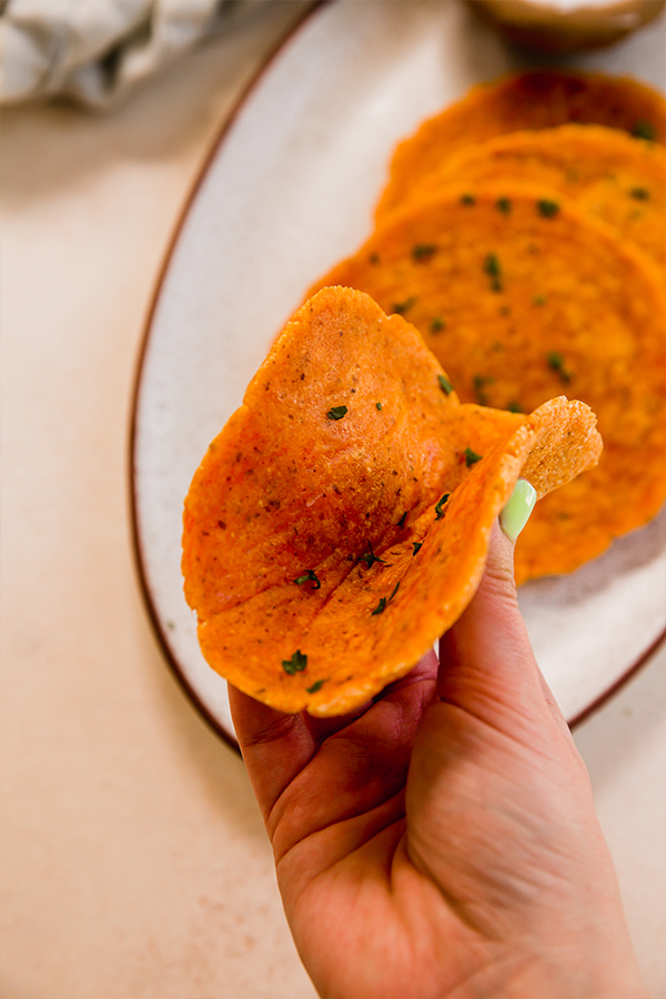A sweet potato flatbread held in a hand.