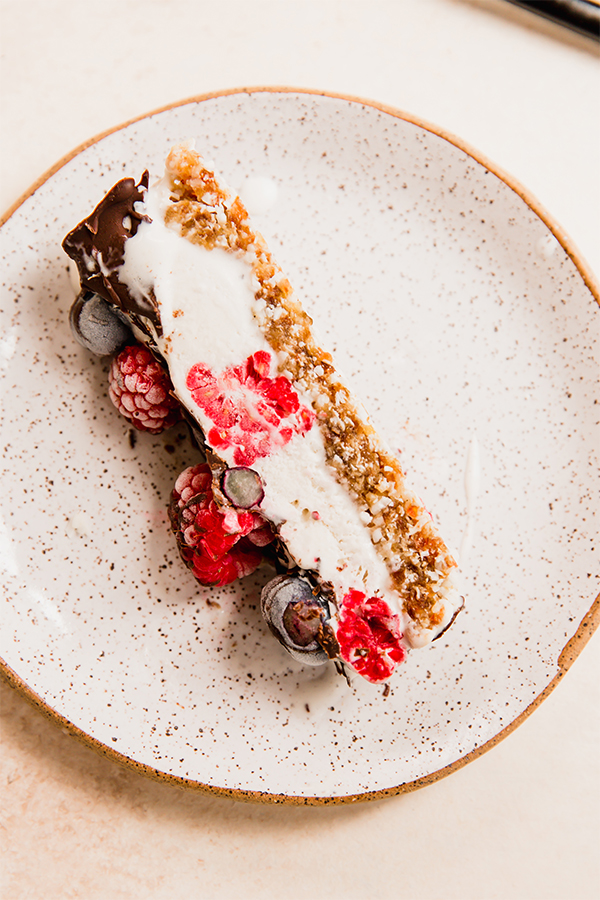 Slice of no bake berry vanilla ice cream cake on its side.