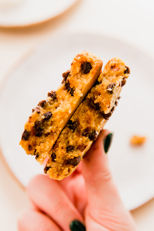 The single serve pumpkin cookie split in half in a hand.