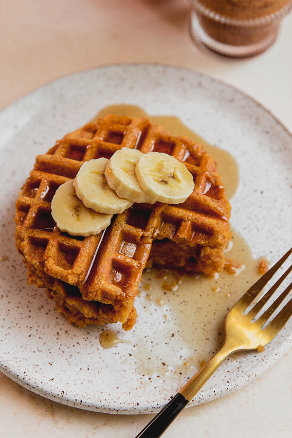 A stack of pancakes with banana and maple syrup on it.