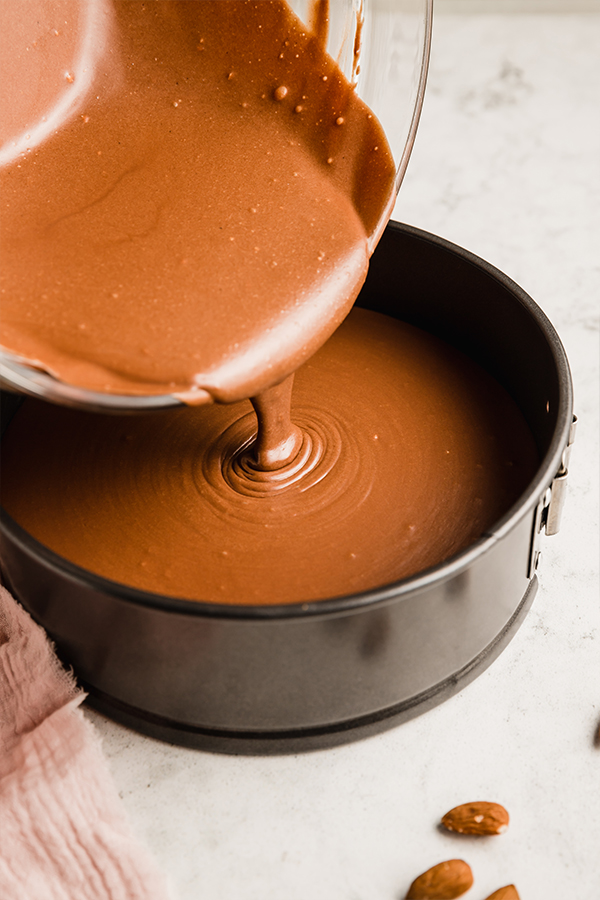 Chocolate filling pouring into a springform pan.