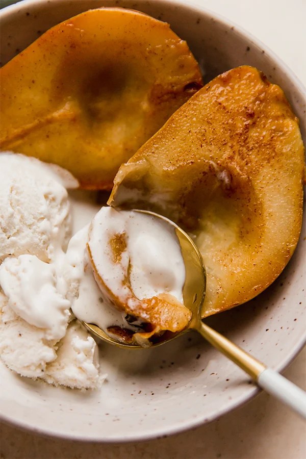 Spoon digging into a baked pear.
