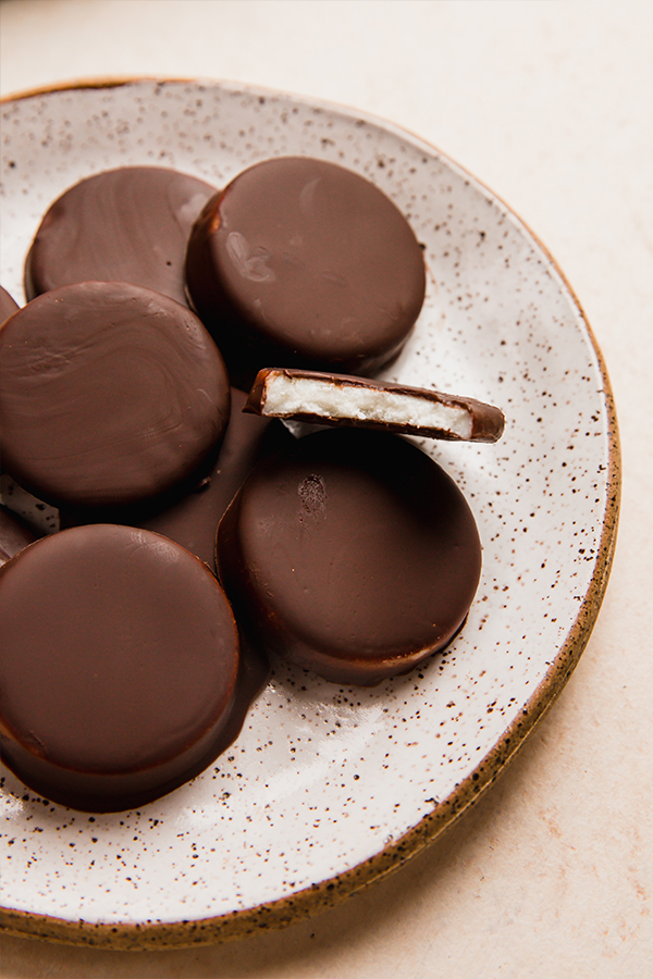 Plate of peppermint patties, one of which is missing a bite.