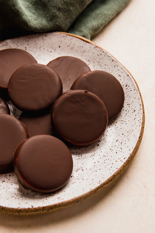 Homemade peppermint patties piled on a plate.