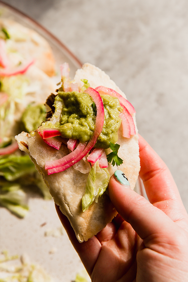A baked shredded beef taco in a hand.