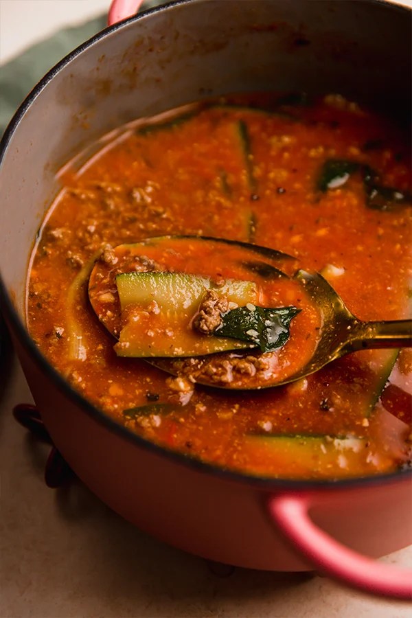 Pot of lasagna soup with a spoon.