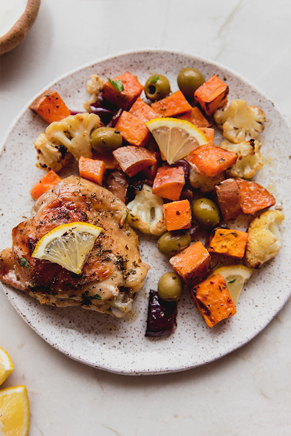 A plate with chicken and vegetables from the sheet pan meal.