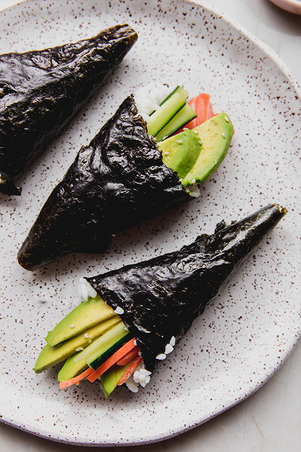 Several sushi hand rolls on a plate.