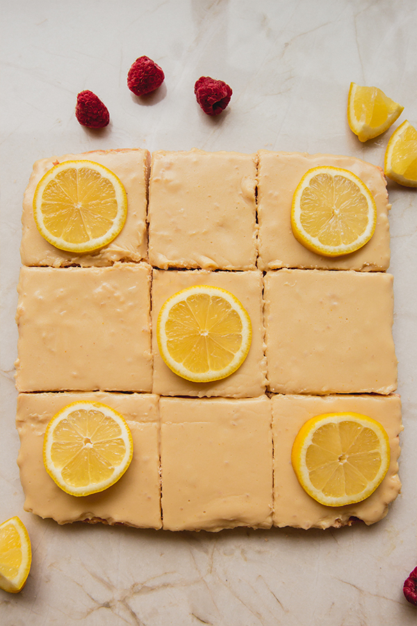 Lemon bars, some of which are topped with lemon slices.