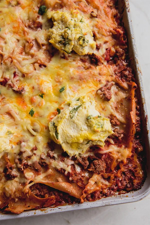 Dollop of ricotta on lasagna with melted cheese.