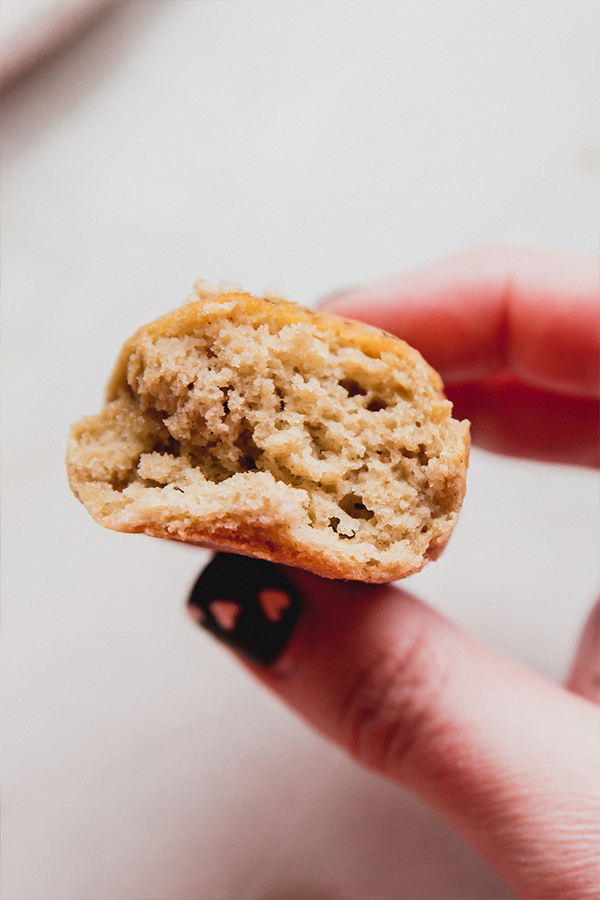 A breadstick being held in a hand after a bite was taken.