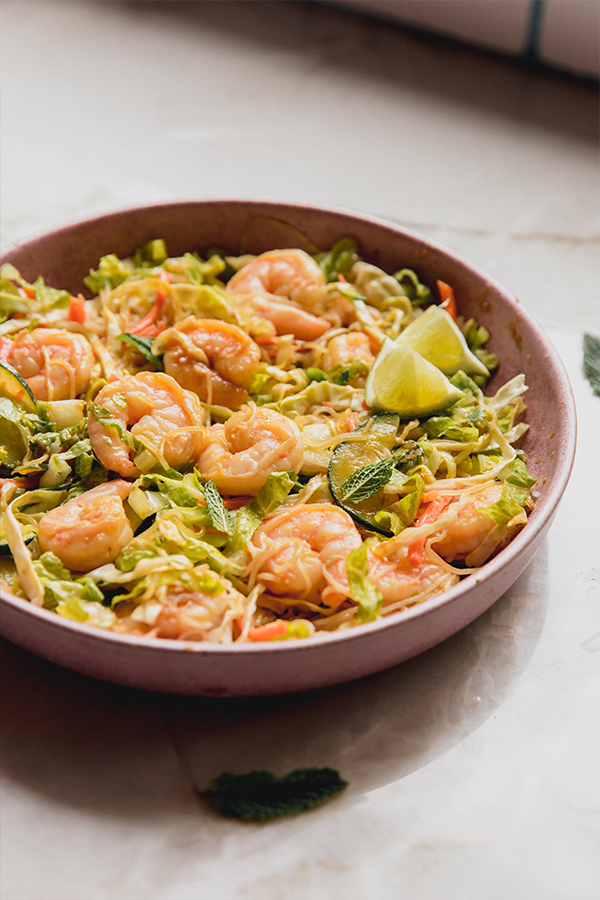 Spring roll in a bowl topped with lime.