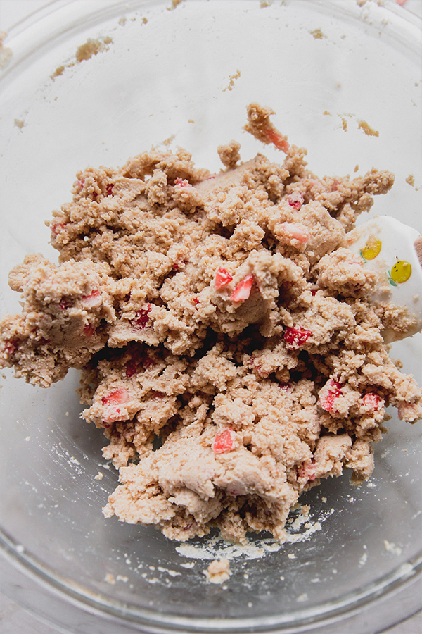 The dough for strawberry mini donuts in a glass bowl.