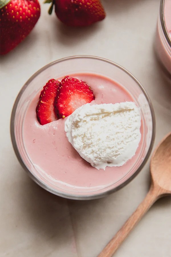 Strawberry slices on a bowl of dairy free strawberries and cream pudding.