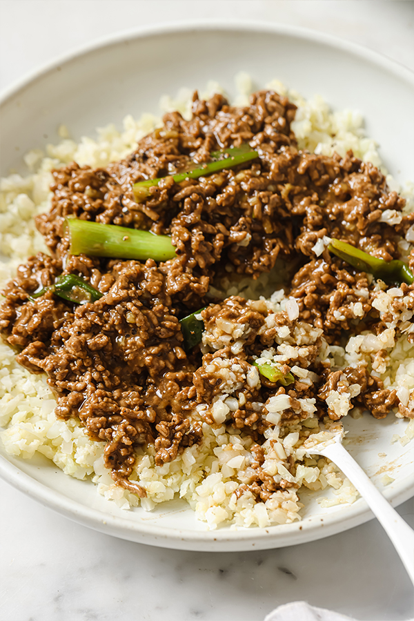 Fork on a plate with Mongolian ground beef and rice.