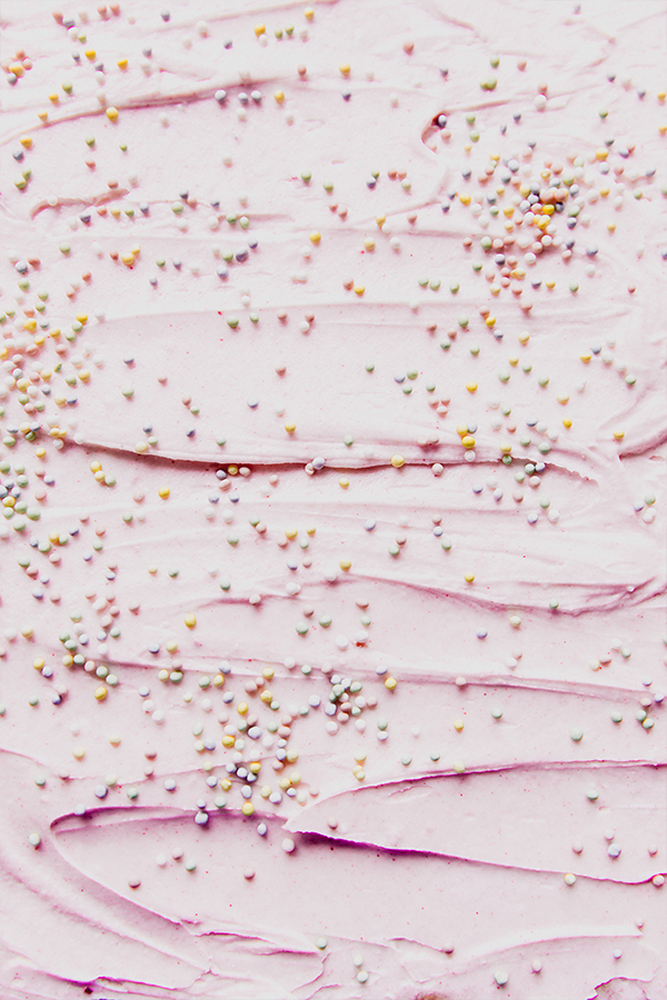 A tray of funfetti pink sugar cookie bars with pink icing and sprinkles.