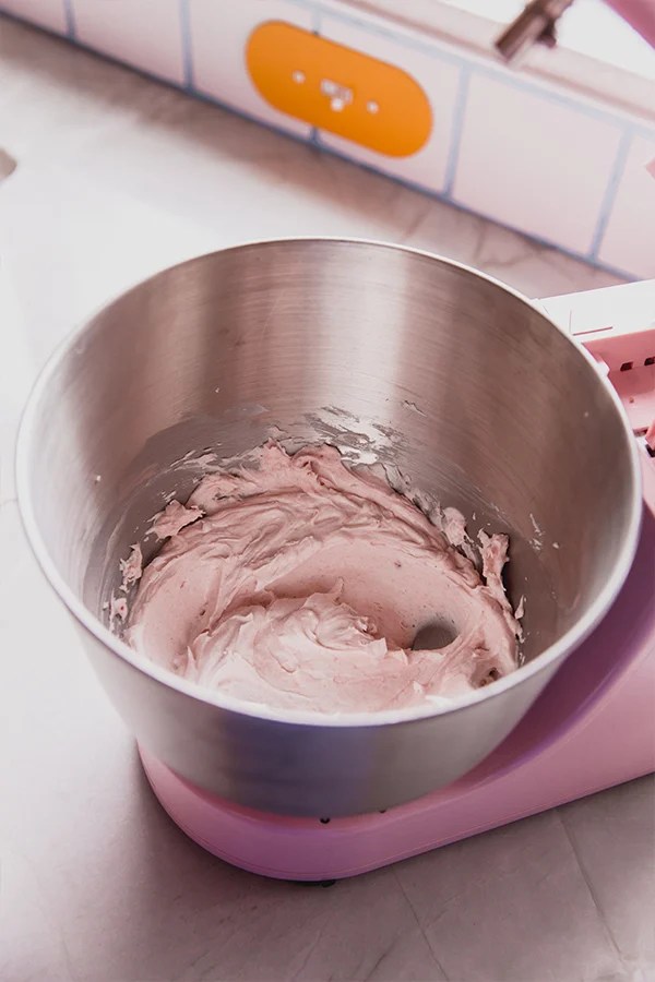 A metal mixing bowl with the icing after mixing.