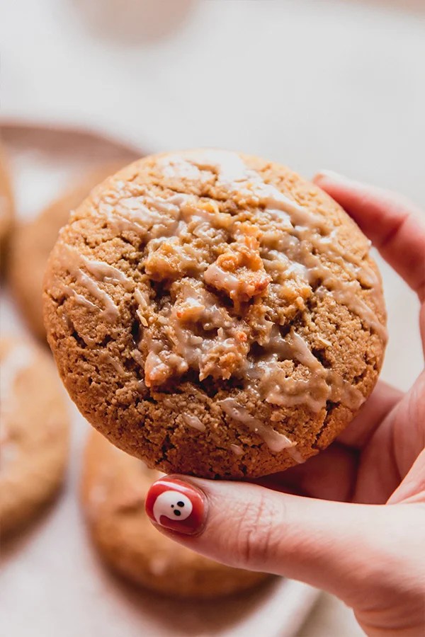 Person with a ghost painted on their nail holding a coffee cake cookie.
