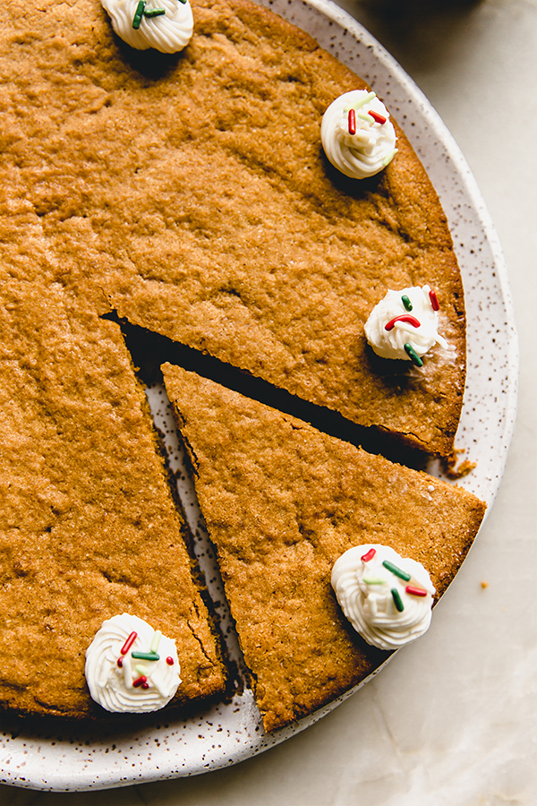 Slice being removed from a gingerbread cookie cake.
