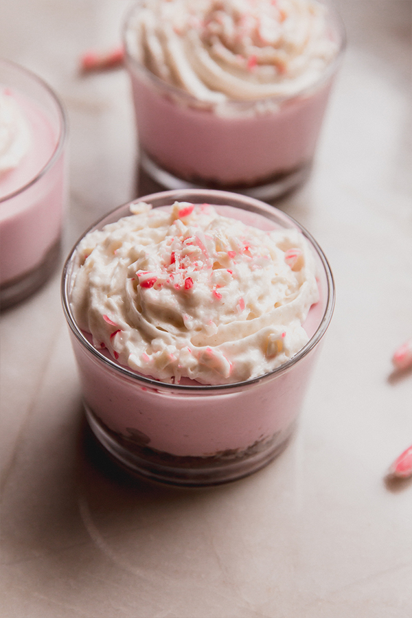Peppermint pie cheesecake cup topped with crushed candy.