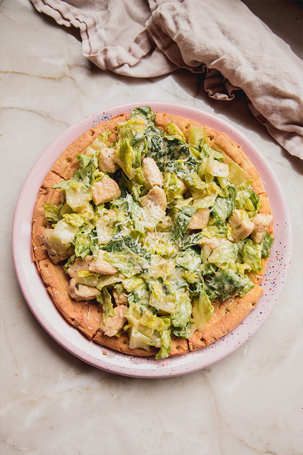 Plate of chicken Caesar salad pizza.
