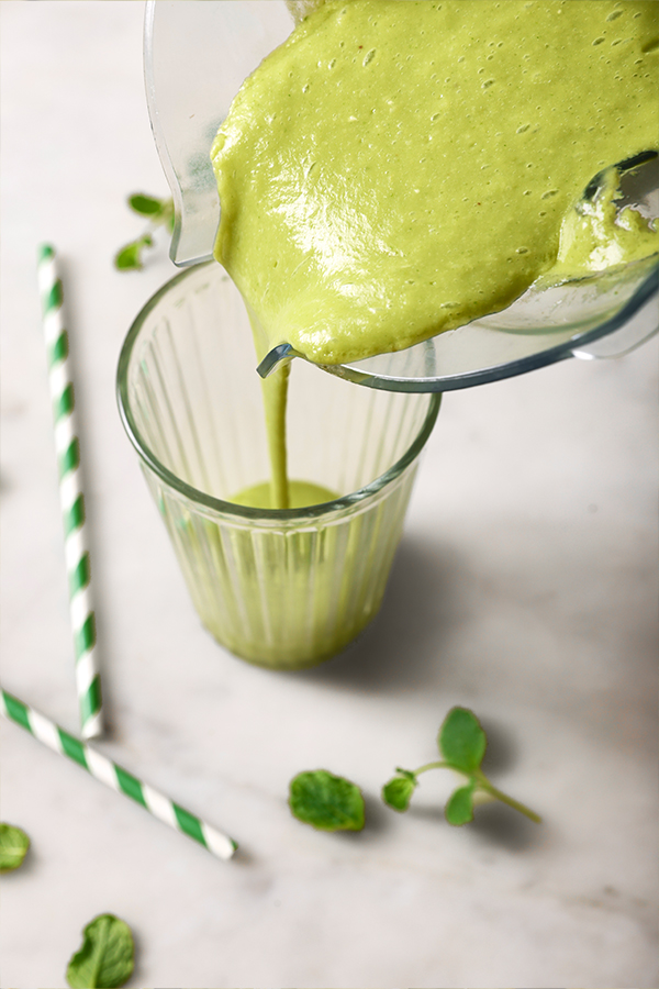 Blender pouring Shamrock shake into a glass.