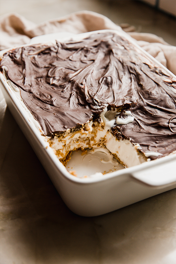 Gluten free eclair cake in a baking dish with a slice cut out.